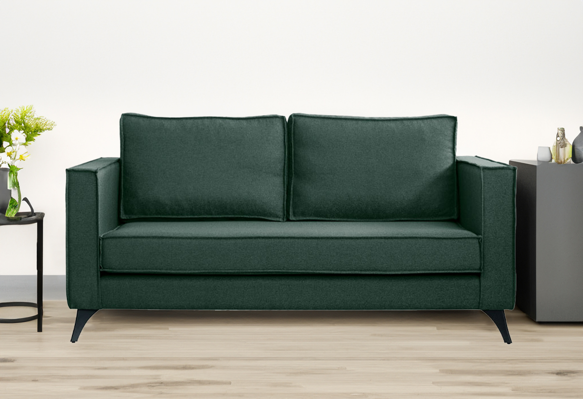 Απεικονίζεται ο πράσινος καναπές τοποθετημένος σε σαλόνι ενώ μπροστά υπάρχει μία μοκέτα.